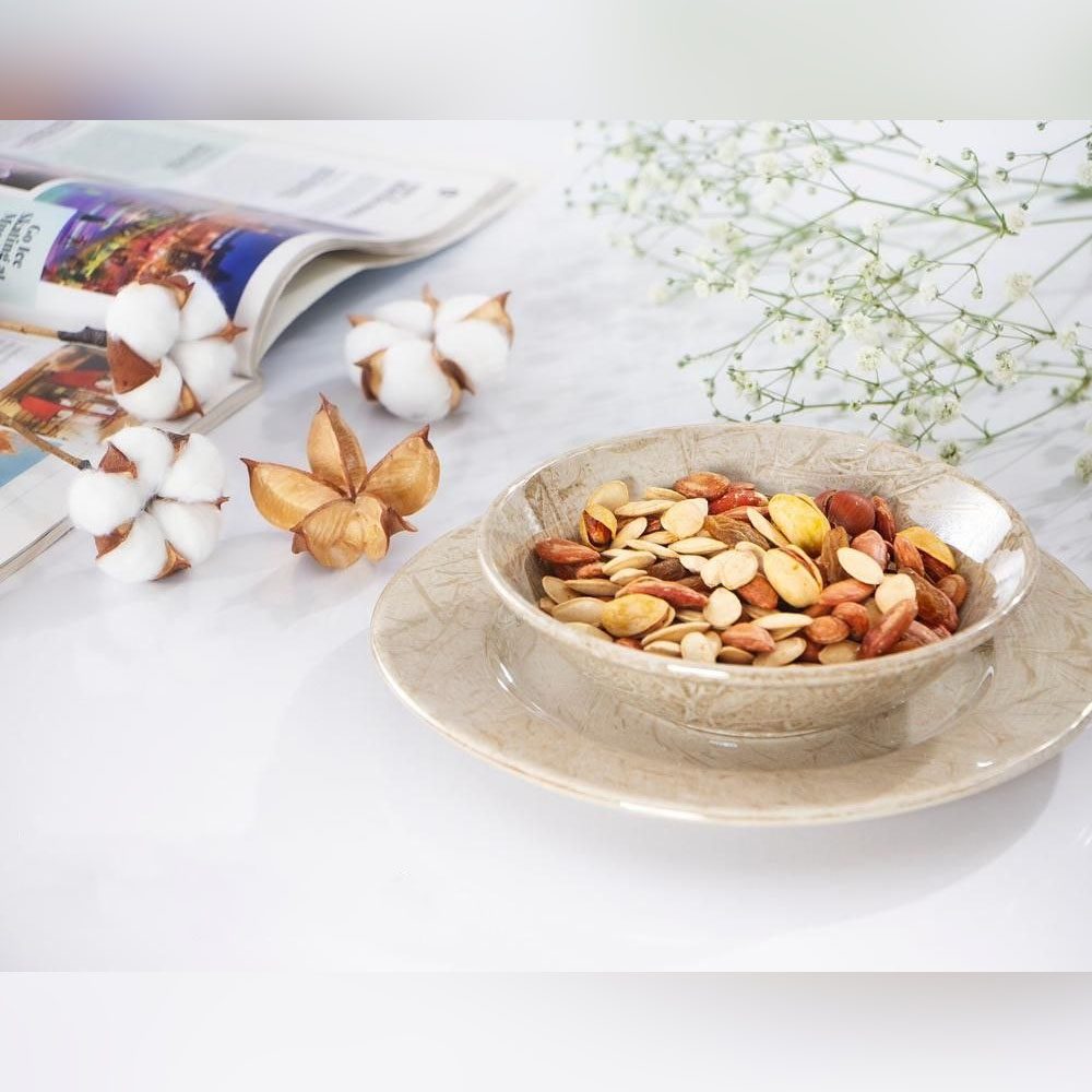 پیاله و پیش دستی ماربل 18120-8 و 18121-8 پیاله سرامیکی طرح ماربل پر از آجیل که روی پیش دستی ست خود قرار گرفته است