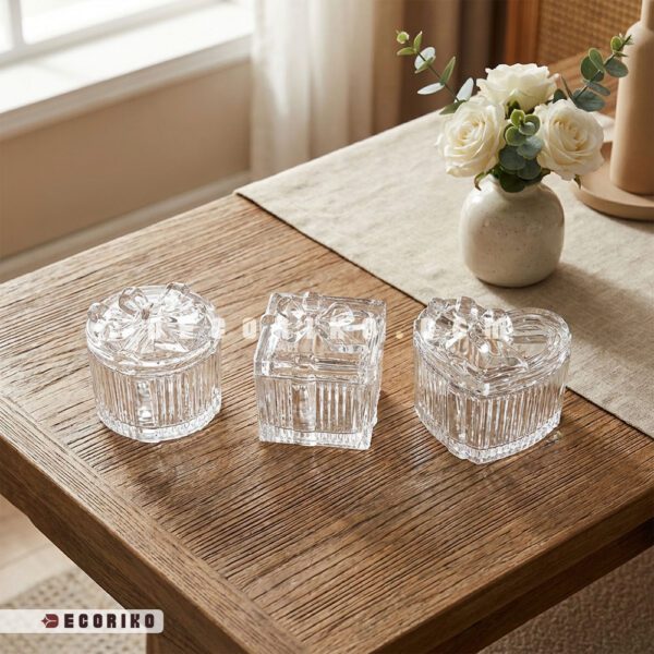 سه مدل قندان بلور طرح پاپیون در شکل‌های گرد، مربع و قلبی روی میز چوبی