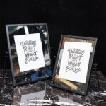 دو عدد قاب عکس دکوری رومیزی شیشه‌ای مشکی با متن انگیزشی.