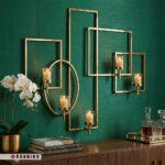 شمعدان دیواری طلایی ۵ شعله لوکس نصب شده روی دیوار سبز تیره