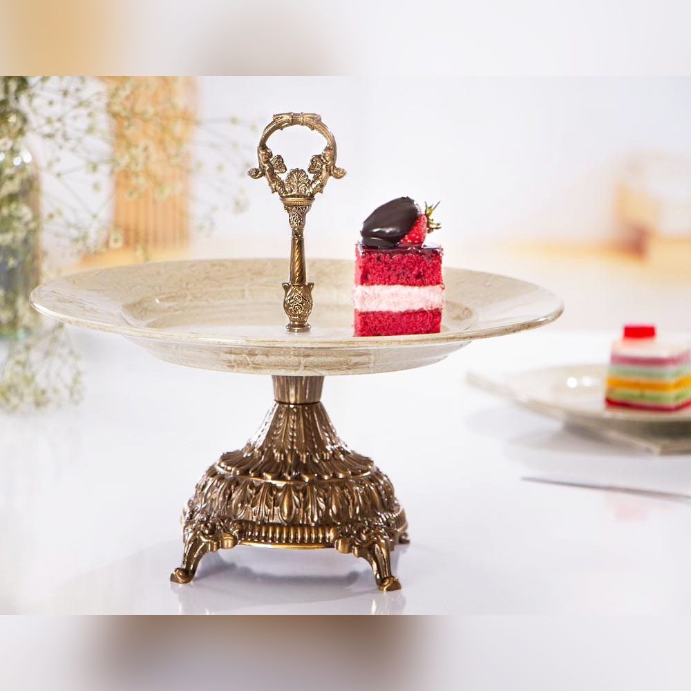 شیرینی خوری پایه دار آنتیک مدل ماربل با دسته فلزی و یک تکه کیک روی سینی