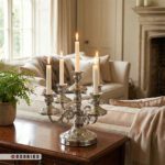 شمعدان رومیزی نقره ای شیک با شمع های روشن روی کنسول چوبی