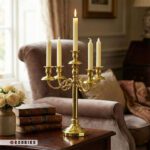 شمعدان ۵ شعله طلایی کلاسیک روی میز چوبی مناسب دکوراسیون گرم