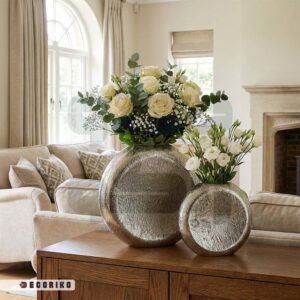 چیدمان گلدان آلومینیومی مدرن با گل رز سفید روی میز چوبی